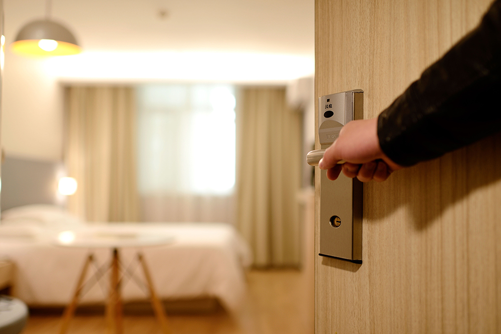 Generic hotel door being opened with one hand